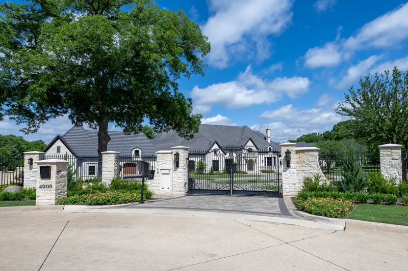 Gated stone entrance with wrought iron drive gate at Bella Terra Estate, Parker TX