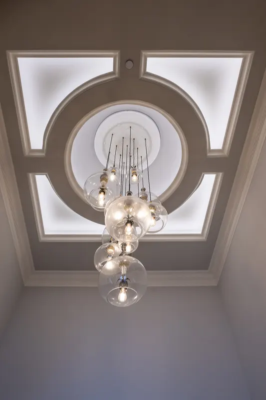 Foyer ceiling detail with circular tray molding and clustered glass globe chandelier