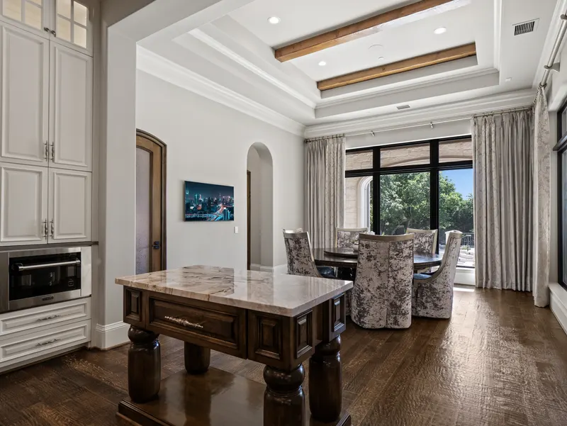 Breakfast room with a marble-topped prep island and window-lined banquette dining