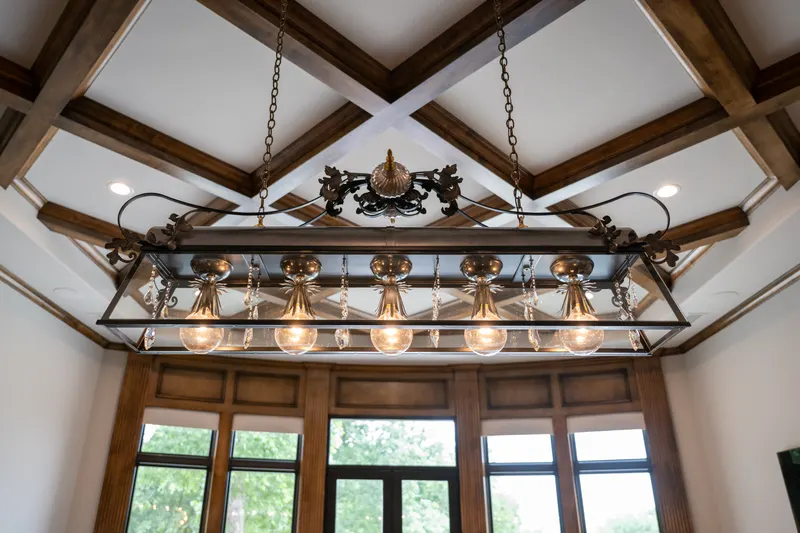 Coffered game room ceiling with an iron and glass billiard light fixture