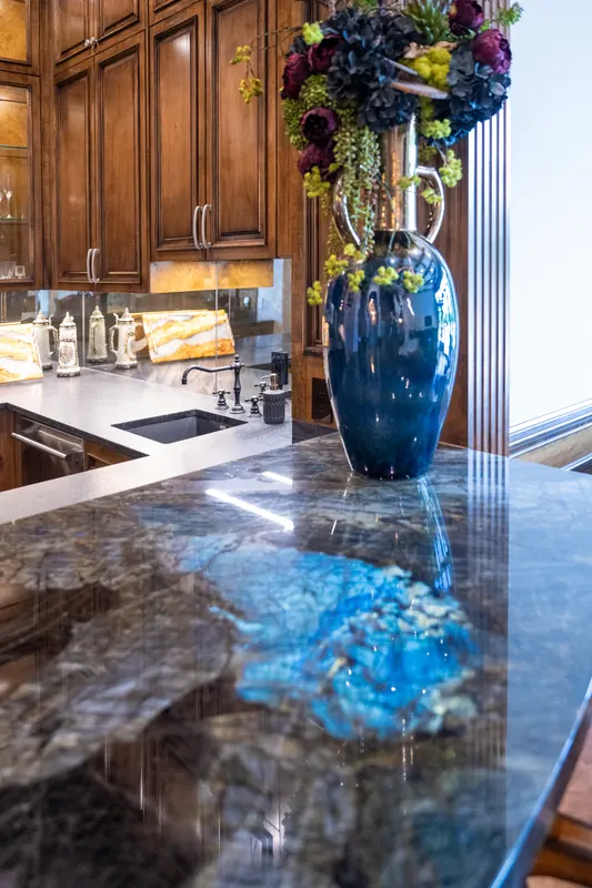 Bar counter detail in blue labradorite granite with a tall cobalt vase