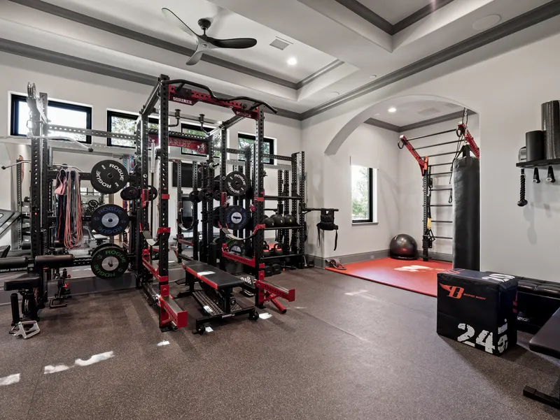 Home gym with Rogue power rack, free weights and rubber-matted flooring