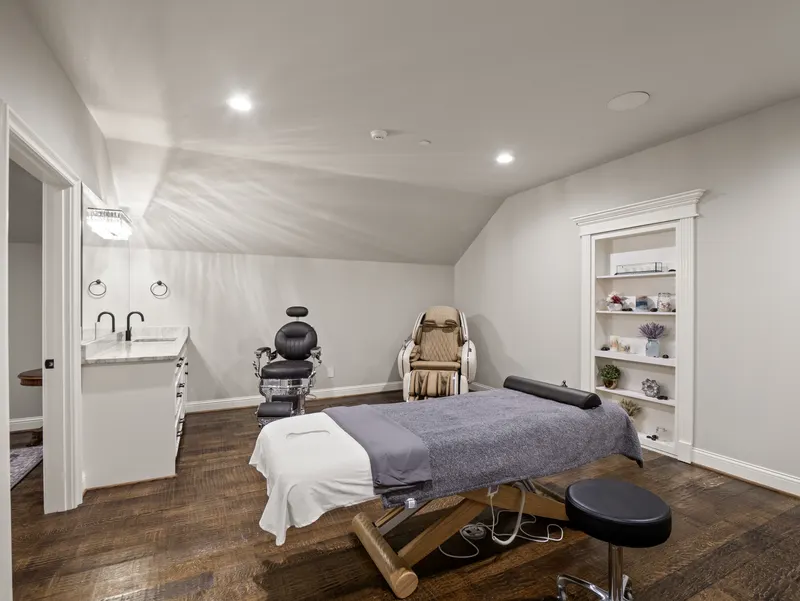 Spa room with massage table, zero-gravity chair and built-in display shelves