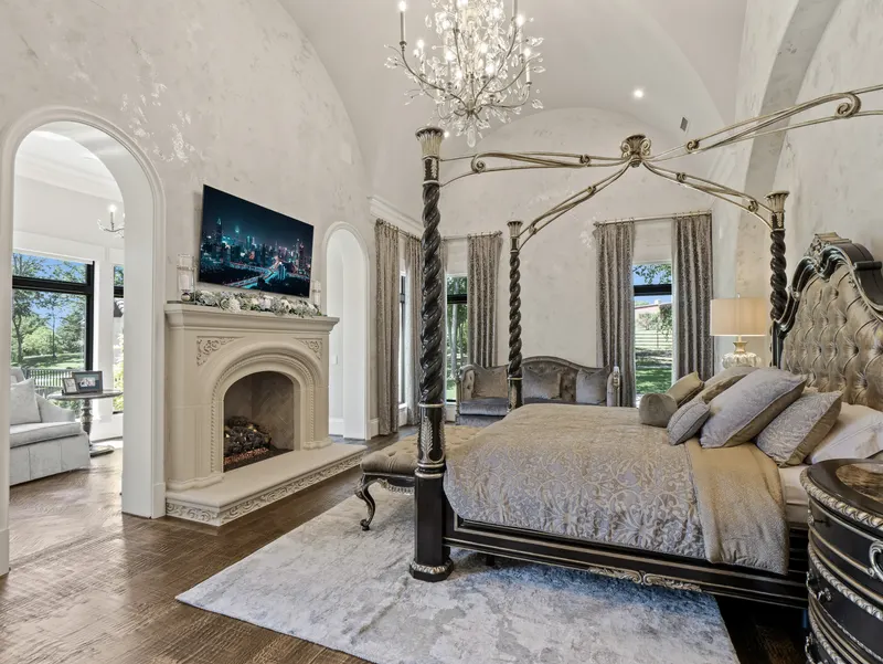 Master suite with groin-vault ceiling, crystal chandelier, four-poster bed and cast stone fireplace