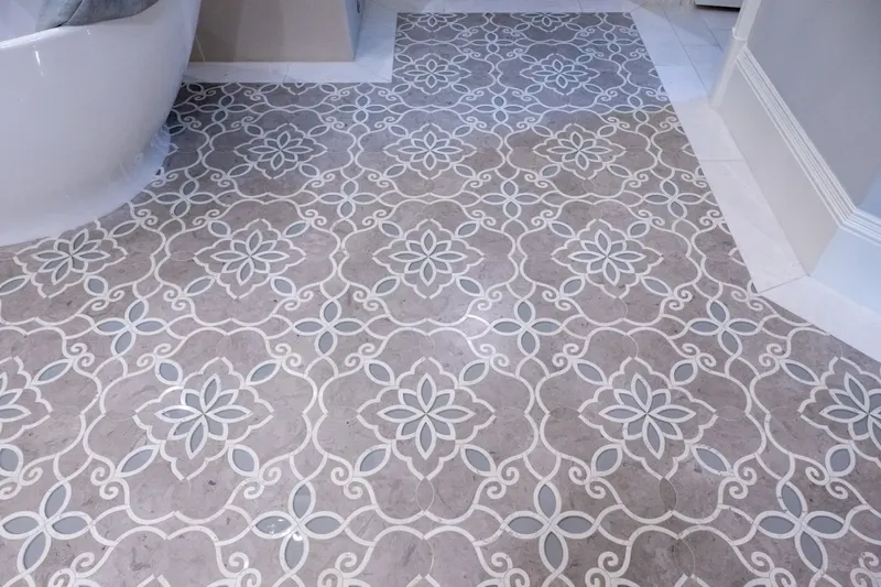 Master bath floor in gray and white marble mosaic beside the freestanding soaking tub