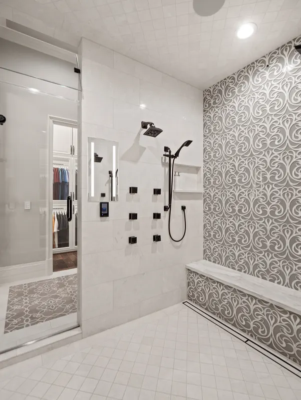 Walk-in master steam shower with body sprays, marble bench and silver damask accent wall