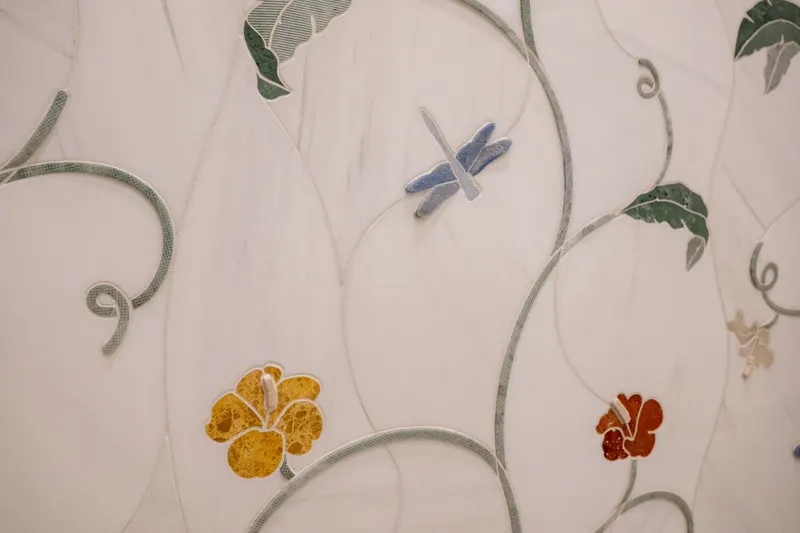 Hand-cut marble mosaic inlay with dragonfly, vines and amber blossoms in a guest bath