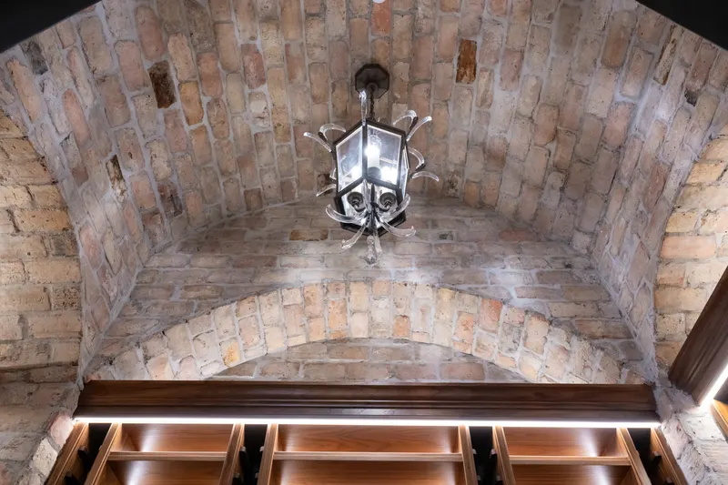 Reclaimed brick groin vault and wrought iron lantern above the wine room racking