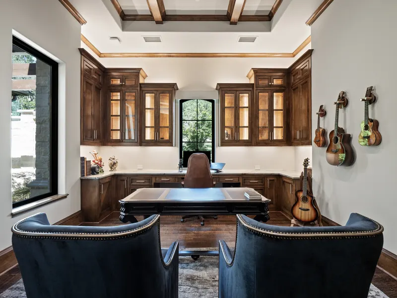 Executive office with walnut built-ins, glass-front cabinets and a leather-top desk