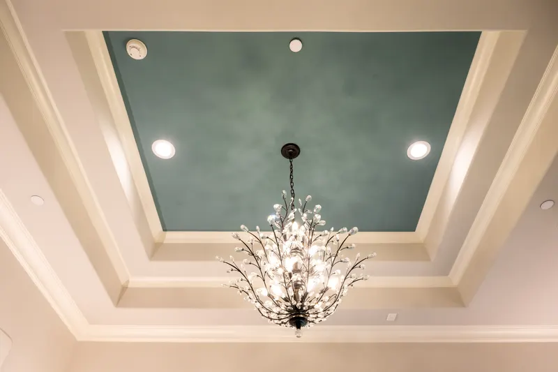 Stepped tray ceiling with a teal center panel and crystal branch chandelier