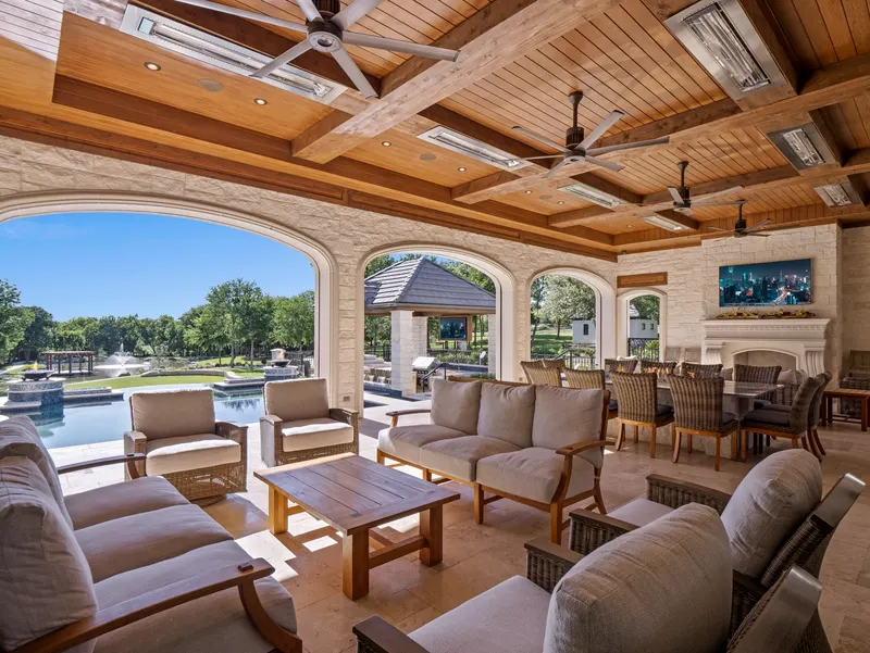 Covered outdoor living room with cedar ceiling, fireplace and pool views at Bella Terra Estate, Parker TX