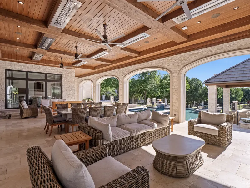 Arched loggia with wicker lounge seating overlooking the resort pool at Bella Terra Estate, Parker TX