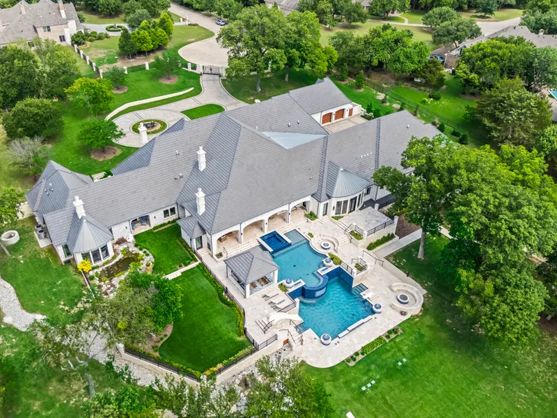 Aerial of the single-story estate with slate roofs and two-level pool at Bella Terra Estate, Parker TX