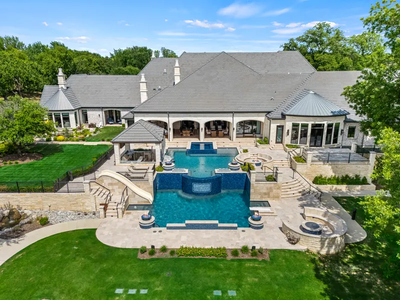 Rear elevation with arched loggia, waterfall pool and curving slide at Bella Terra Estate, Parker TX