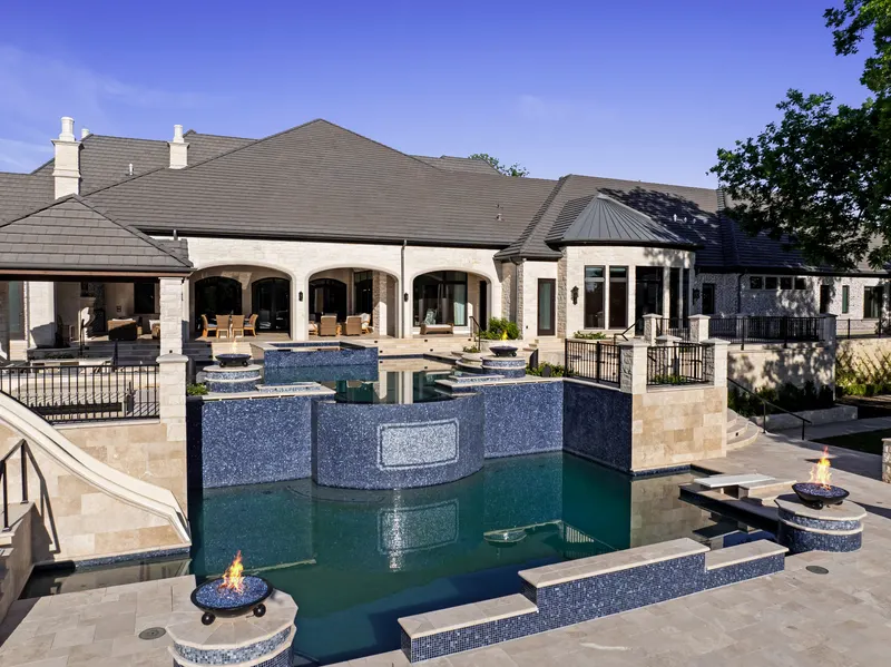 Elevated view of the covered patio and mosaic-tile pool wall with fire bowls at Bella Terra Estate, Parker TX