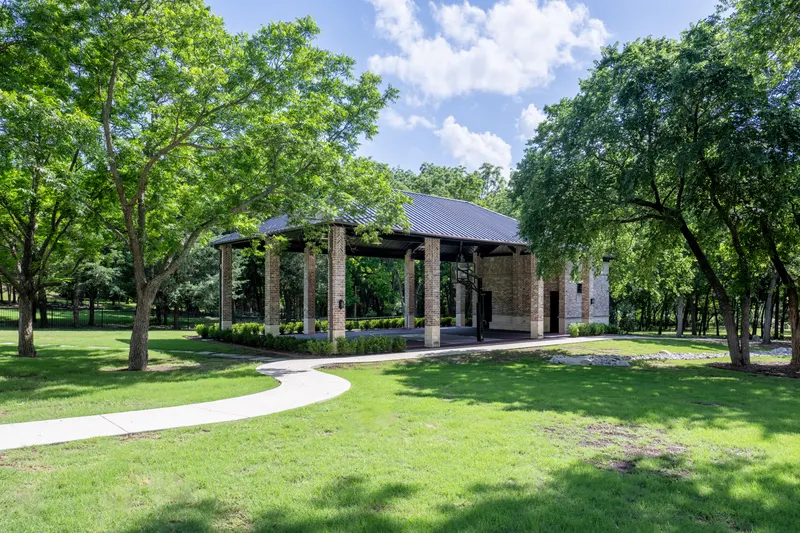 Covered brick-column sport court pavilion off a curving walking path at Bella Terra Estate, Parker TX
