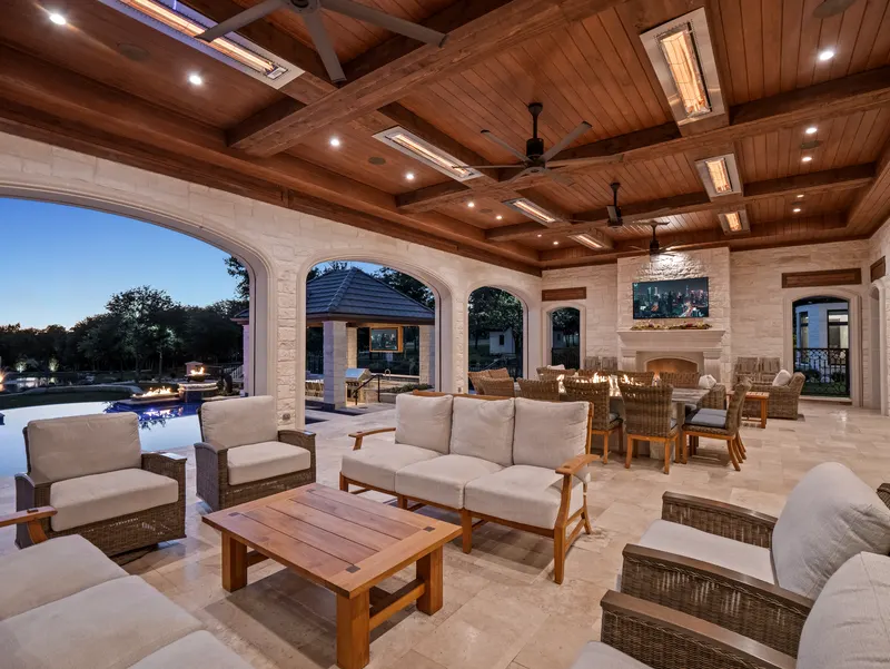 Covered outdoor living room with coffered cedar ceiling, fireplace and poolside dining