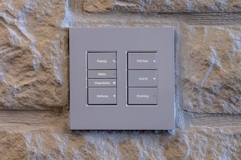 Control4 lighting keypad set into stone with labeled Family, Kitchen and Evening scenes