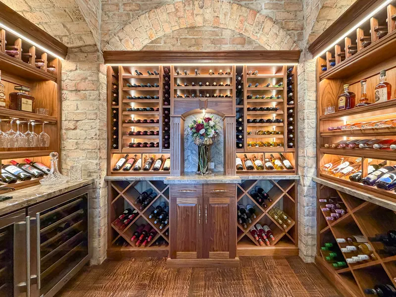 Wine room with reclaimed Chicago brick barrel ceiling, walnut racks and wine fridge